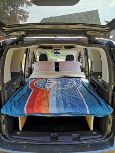 opgemaakte bed met de Voited dekens op de camper uitbouw voor de mini camper Volkswagen Caddy