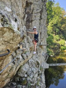 Caroline klimt op de rotsen op het Aquarock klimparcours in de Ardèche
