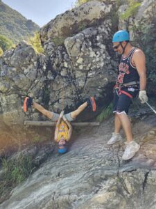 Lewis hangt ondersteboven op het Aquarock klimparcours in de Ardèche